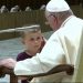 Un niño se acerca durante la audiencia semanal del papa Francisco y permanece a su lado durante unos minutos